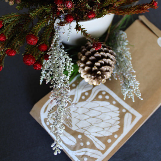 Handmade christmas gift wrapping with a protea print by Spaza Store